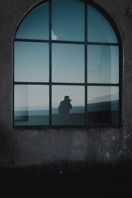 人站在窗户旁边的剪影照片 · 免费素材图片