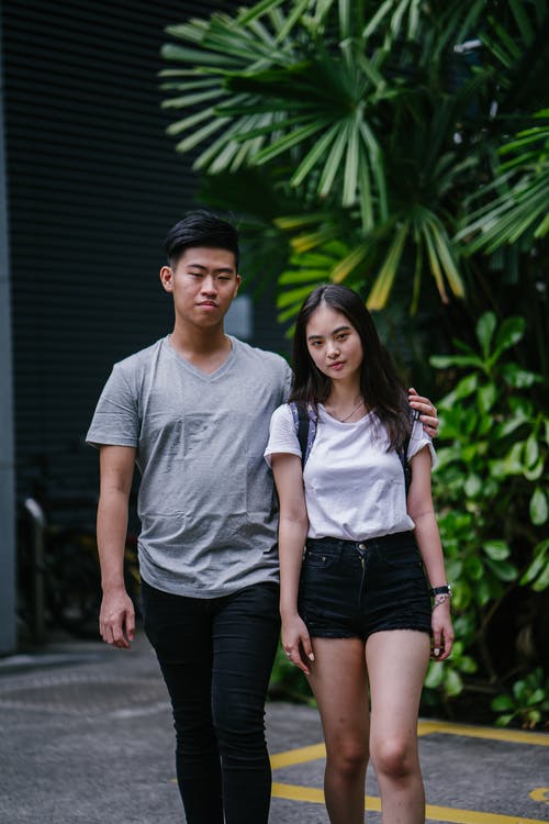 女人和男人走在绿叶植物附近 · 免费素材图片