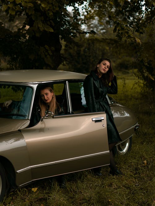 2名妇女在一辆棕色的老式汽车内 · 免费素材图片