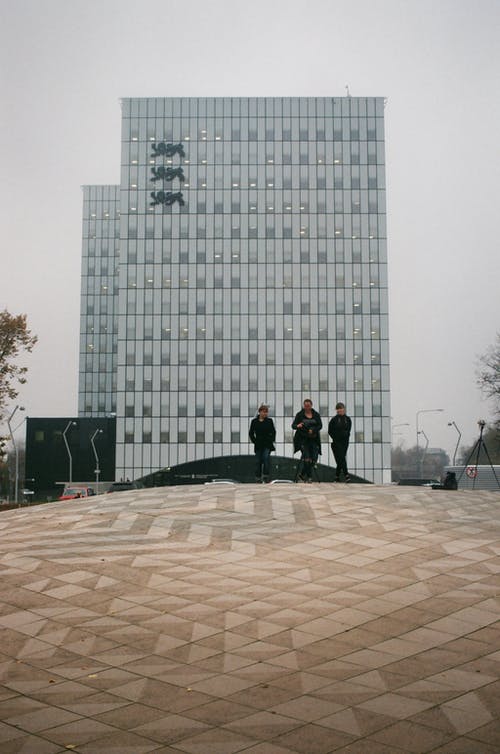 三人在混凝土路面上行走 · 免费素材图片