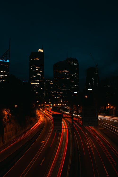 晚上与建筑物在背景中的照明高速公路的延时照片 · 免费素材图片