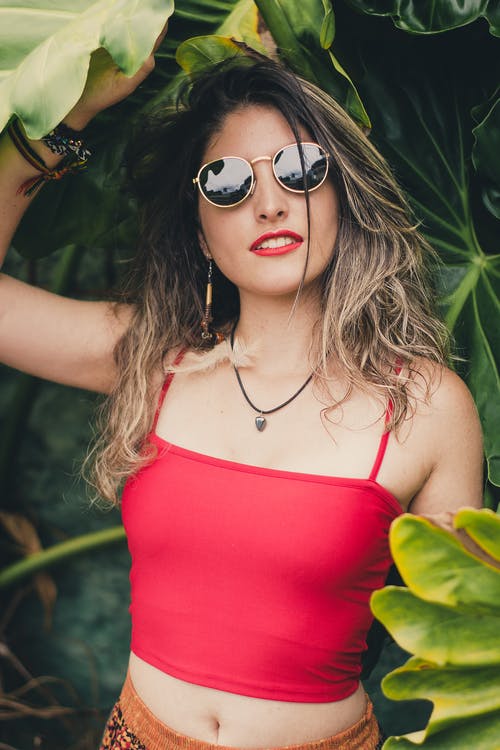 女人穿着红色作物顶部控股叶 · 免费素材图片