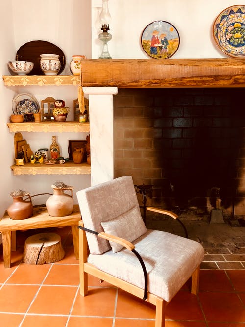 壁炉旁的棕色木制框架软垫灰色扶手椅 · 免费素材图片