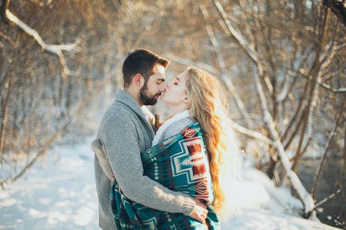男人和女人互相拥抱，要在下雪季节接吻 · 免费素材图片