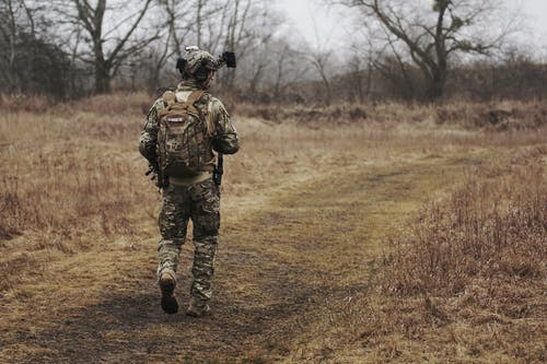 男人穿军装，走过树林 · 免费素材图片