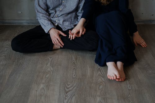 男人和女人坐在木地板上 · 免费素材图片
