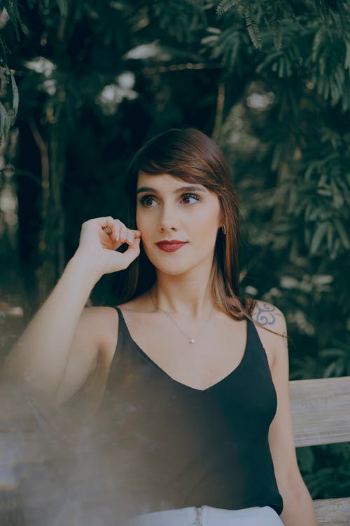 女人坐在棕色的木凳上的选择性聚焦摄影 · 免费素材图片