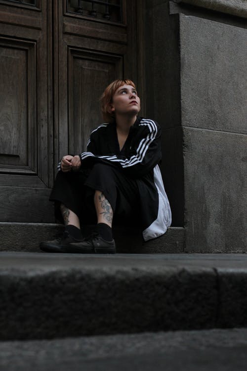 坐在木门附近的女人 · 免费素材图片