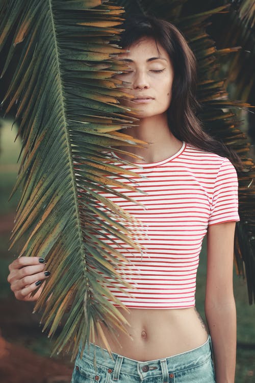 女人抱着棕榈叶的照片 · 免费素材图片