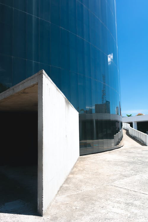 玻璃建筑旁边的白色混凝土墙 · 免费素材图片