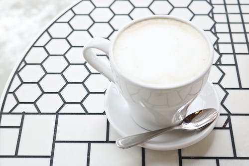 白色陶瓷茶杯带茶碟和不锈钢茶匙 · 免费素材图片