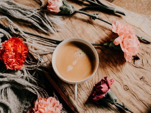 花被包围的杯子里的咖啡 · 免费素材图片