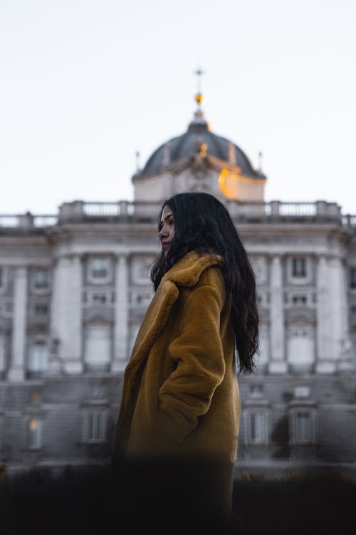 女人站在灰色清真寺附近 · 免费素材图片