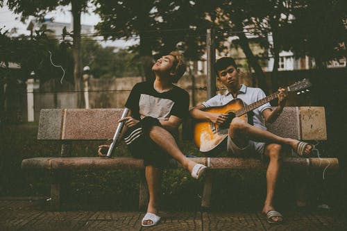 在另一个男人旁边弹吉他的男人的照片 · 免费素材图片
