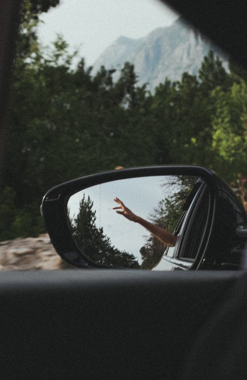 人的手在汽车后视镜上反映出来 · 免费素材图片