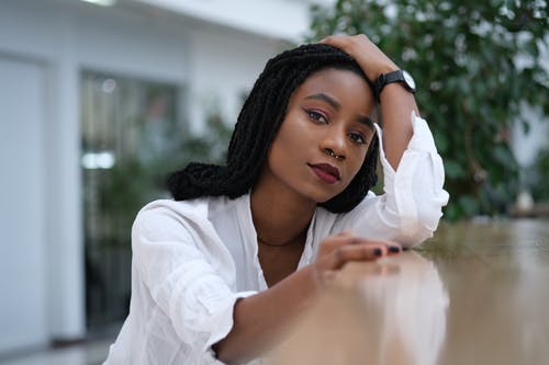 倾斜在木质表面上时握住她的头发的女人的照片 · 免费素材图片