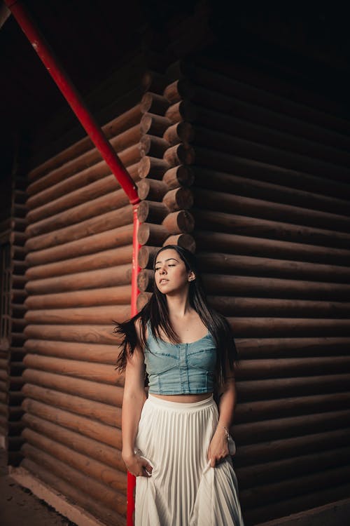 站在棕色墙上的女人 · 免费素材图片