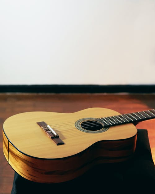 墙内室附近的地板上的棕色原声吉他 · 免费素材图片
