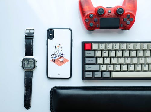 键盘，Iphone X和数字手表旁边的dualshock 4的平躺摄影 · 免费素材图片