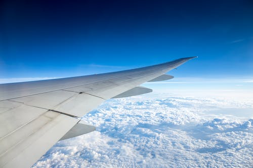 飞机飞越多云的天空 · 免费素材图片