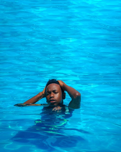 在蓝色的水面上游泳的人 · 免费素材图片