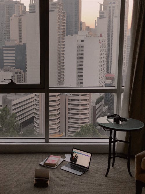 玻璃窗旁边的开机笔记本电脑 · 免费素材图片