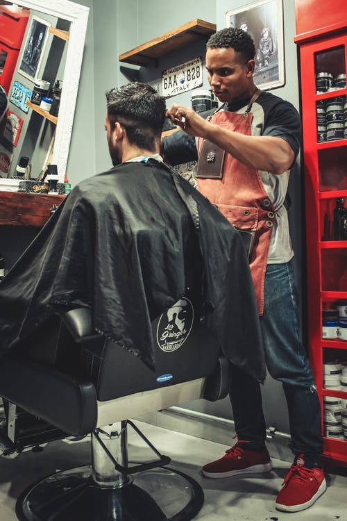 坐在理发椅上的男人剪头发的男人 · 免费素材图片