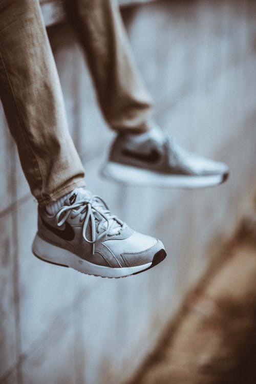穿着灰色耐克鞋的人的选择性聚焦照片 · 免费素材图片