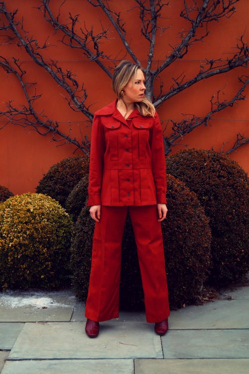 女人站在修剪的花园附近 · 免费素材图片