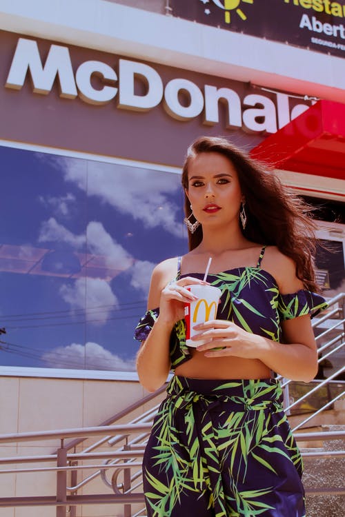 女人抱着麦当劳塑料杯的照片 · 免费素材图片