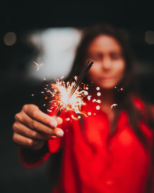 女人拿着烟花的选择性焦点摄影 · 免费素材图片