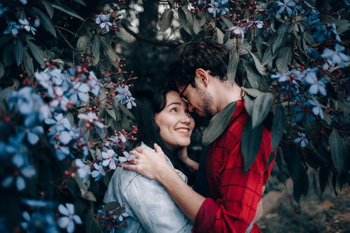 男人和女人在花丛中拥抱 · 免费素材图片