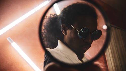 透过镜子看戴戴嬉皮太阳镜的男人 · 免费素材图片