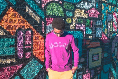 男子倚着五彩的墙 · 免费素材图片