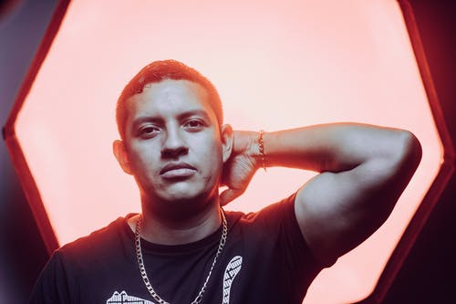 男子倚在带灯的墙上 · 免费素材图片