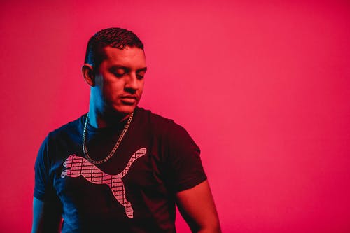 男子站在红墙附近 · 免费素材图片