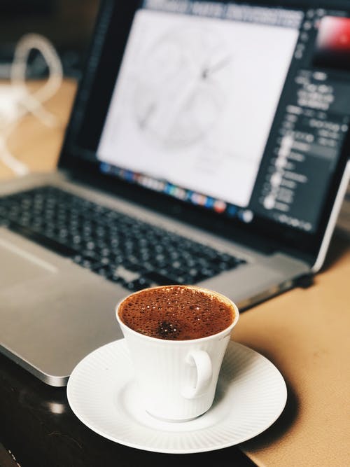 笔记本电脑附近的咖啡杯的选择性聚焦照片 · 免费素材图片