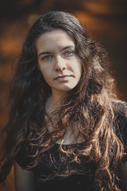 站立的妇女穿黑瓢脖子衬衣 · 免费素材图片