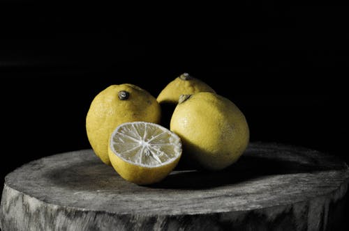 在树板上切柠檬旁边的三个柠檬 · 免费素材图片