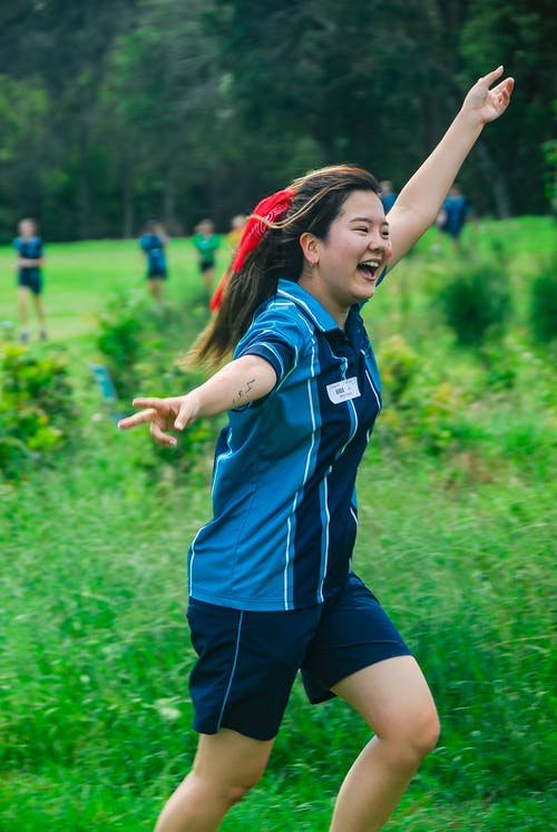 女人穿着蓝色polo衫举起左手的浅焦点照片 · 免费素材图片