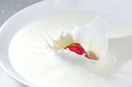 草莓落在牛奶上的延时摄影 · 免费素材图片