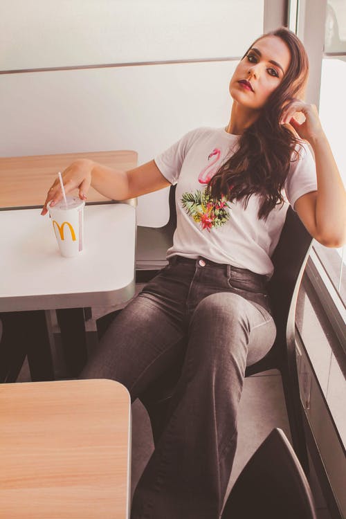 女人坐下来拿着麦当劳杯 · 免费素材图片