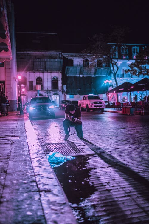 夜间拍摄车辆前地面的人 · 免费素材图片