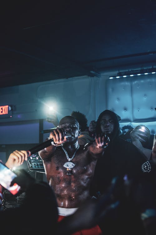 男子戴着银色的项链，拿着麦克风 · 免费素材图片