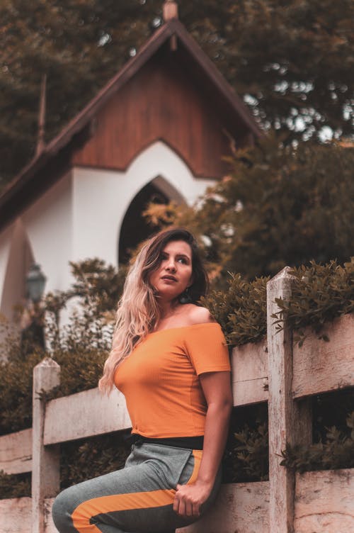 靠在木栅栏上的女人的照片 · 免费素材图片