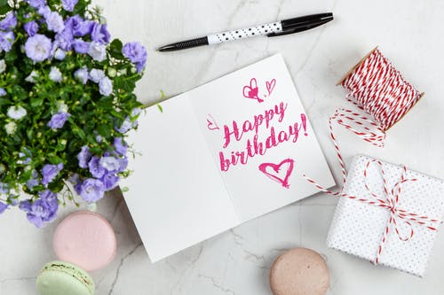 鲜花，线，盒和杏仁饼旁边的生日快乐卡 · 免费素材图片