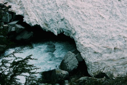 小溪附近的积雪覆盖的岩石 · 免费素材图片