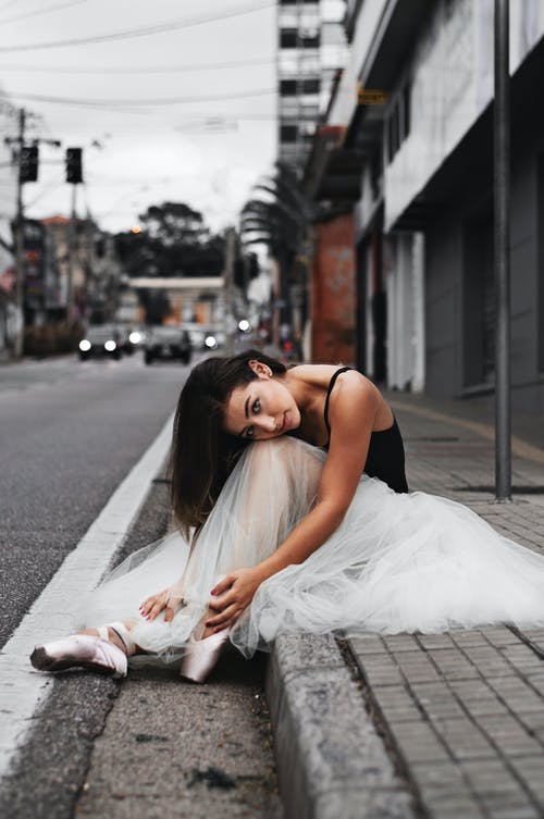 芭蕾舞女演员坐在人行道上 · 免费素材图片
