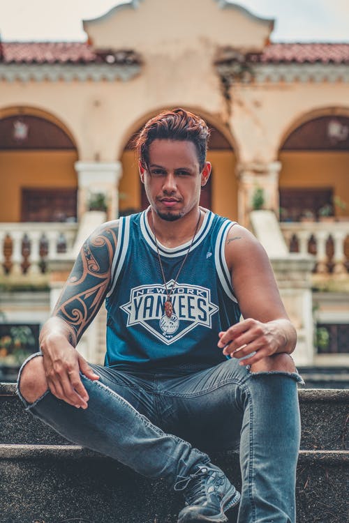 男子坐在大楼附近的楼梯上 · 免费素材图片