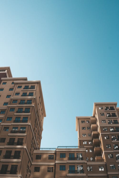 蓝蓝的天空下的高层建筑的低角度摄影 · 免费素材图片